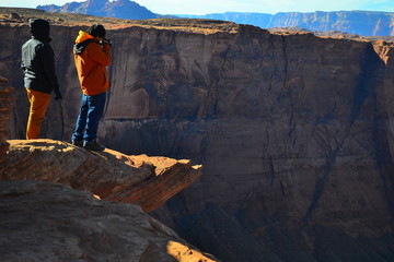 Obraz premium A tourist is taking a photo of Horseshoe Bend near city Page, Arizona
