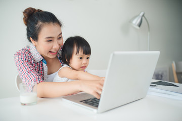 Businesswoman mother woman with a toddler working at the computer