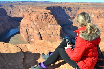 Fototapeta na wymiar Tourist girl is looking at Horseshoe Bend on Colorado River in Arizona