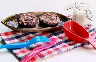Chocolate Brownies on boat plate and jar with milk.