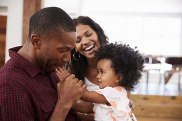 Obraz premium Parents Playing With Young Daughter At Home