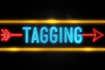 Tagging  - fluorescent Neon Sign on brickwall Front view