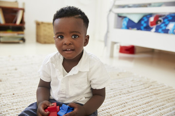Portrait Of Happy Boy Playing With Toys In Playroom © Monkey Business