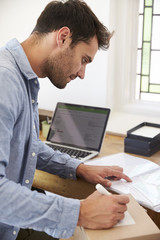 Man In Bedroom Running Business From Home Labeling Goods