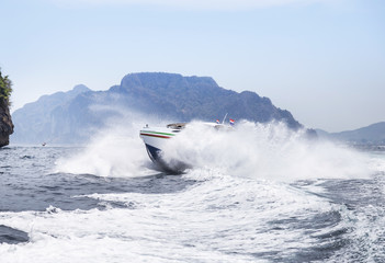 Fototapeta premium speedboat or motorboat sailing on white wave in the tropical sea