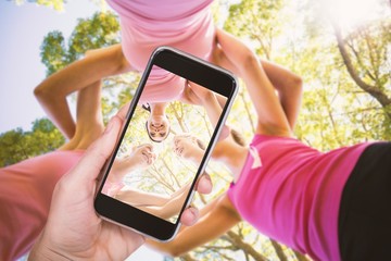 Composite image of hand holding mobile phone against white