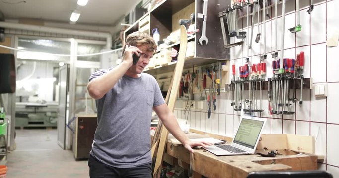Owner making phone call in workshop