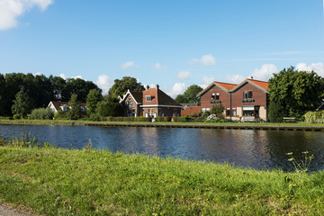 Fototapeta na wymiar Dutch typical houses by the river bank