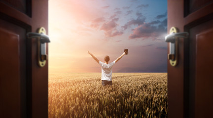 Man praying to God in the field with doors open
