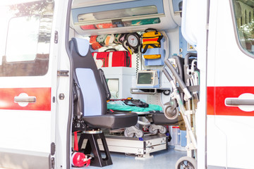Inside the ambulance, view from the sanitary compartment. Different medical equipment and a stretcher. Selective focus, high key.