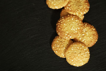 Food background black with small round biscuit. Top view on round cookies with sesame.
