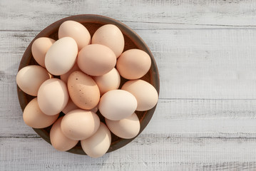 Farm fresh organic brown chicken eggs from free range chickens over a rustic wooden background