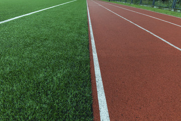Running track and green grass field stadium