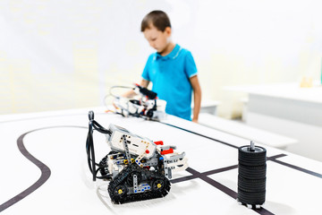 Genius kid working and playing with selfmade robots and microcontrollers