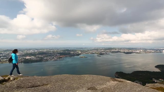Woman is hiking on the top of a mountain in Norway