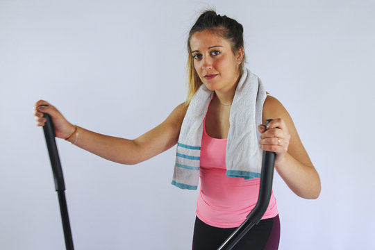 JEUNE FEMME QUI FAIT DU VELO ELLIPTIQUE