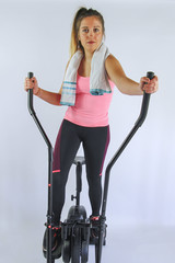 JEUNE FEMME QUI FAIT DU VELO ELLIPTIQUE