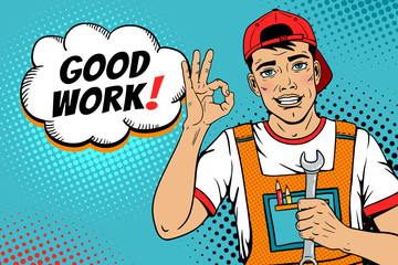 Wow pop art worker face. Young handsome man in coveralls and baseball cap smiles, shows okay sign, holds wrench and Good work! speech bubble. Vector illustration in retro comic pop art  style. 