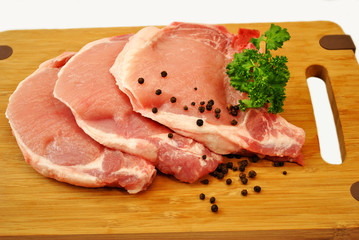 Raw Pork Chops on a Cutting Board
