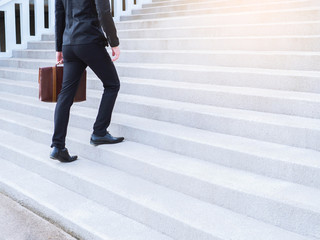 Businessman legs walking up an outdoor stone staircase