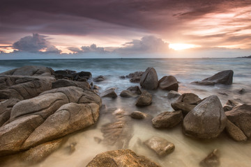 The rock and the sea in the color of sunset time.