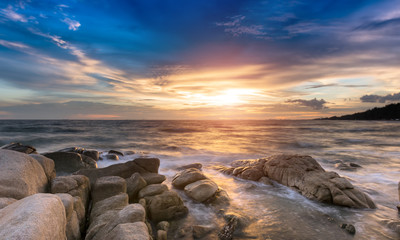 The rock and the sea in the color of sunset time.