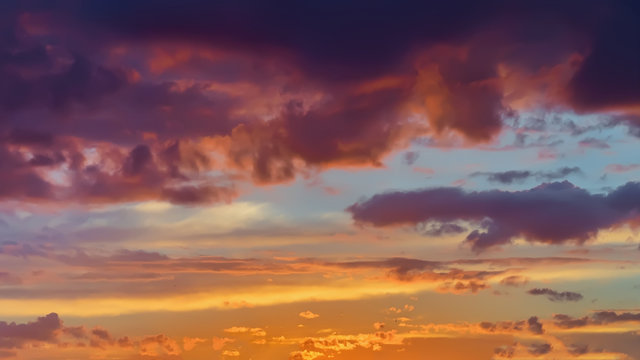 Beautiful golden fiery sunset, vibrant purple clouds, evening sky. Natural background, art shades
