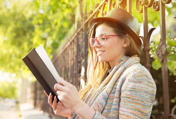 Young woman reading a book outdoors