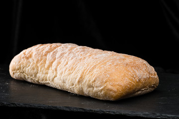 front view of fresh warm homemade bread on dark background