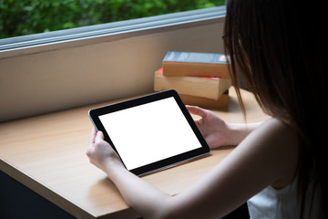 white screen tablet on wooden table with old book