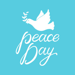 Peace dove with olive branch for International Peace Day poster. Inscription brush Day Peace on blue background