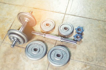 Obraz na płótnie Canvas Iron Dumbbells on the floor showing all parts of it.