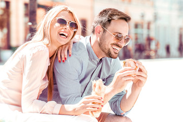 Happy loving couple eating sandwich.