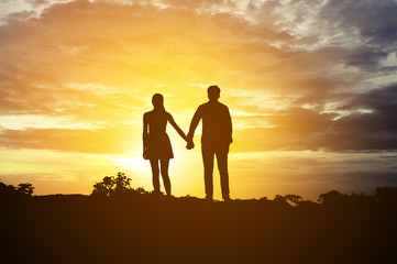 Silhouette Romantic couple in love ,man and women hold hands in nature ,sky with cloud in sunset time