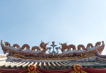 Grunge old Two dragons on the Chinese temple old rooftop with blue sky.