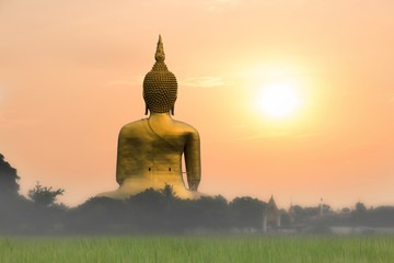 Big golden buddha statue with sunset or sunrise background at Wat Muang, Ang Thong Province, Thailand