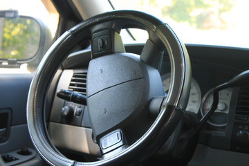 A all black steering wheel with a half turn left parked in a forest