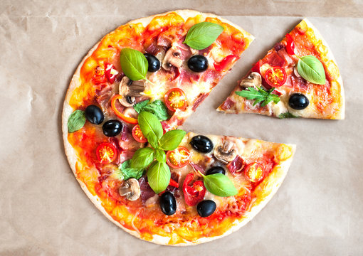 Pizza Margherita with cheese and basil leaf on baking craft paper background with fresh ingredients   for you to design and restaurant menu. Delicious Homemade Cheese  pizza.