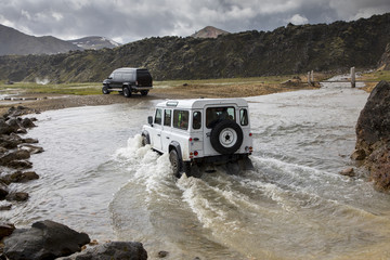 two vehicles fording river in nature park  landmannalaugar in iceland
