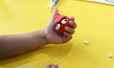 Fototapeta premium kid sculpt red play dough on yellow table