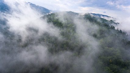 Flight by quadcopter above clouds in mountains