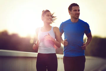 Foto op Plexiglas Beautiful sporty couple running and jogging © NDABCREATIVITY