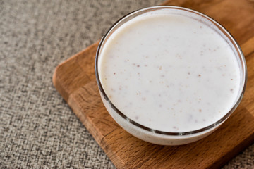 Organic probiotic milk kefir with flax seed in glass bowl.
