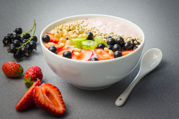 Vegetarian smoothie bowl with berries,nuts and green buckwheat. Selective focus, space for text.