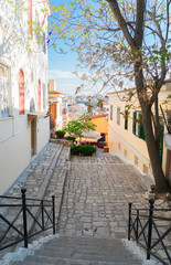 Fototapeta na wymiar small cosy street with steep stairs of famous Placa district in Athens, Greece
