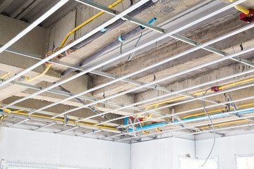 Ceiling construction structure and beam concrete with public utility system tube under construction.