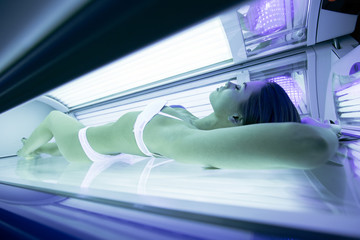 Beautiful brunette sunbathing in solarium