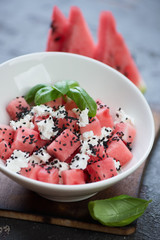 Close-up of watermelon salad with feta cheese and sesame seeds, selective focus, vertical shot