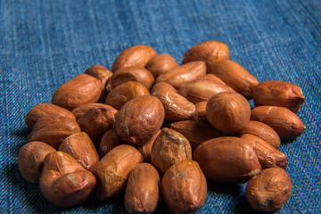 Nuts of peanuts. Macro shot on a jeans background.