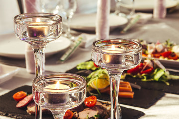 Preparation for the banquet. Candles in candlesticks on tables.